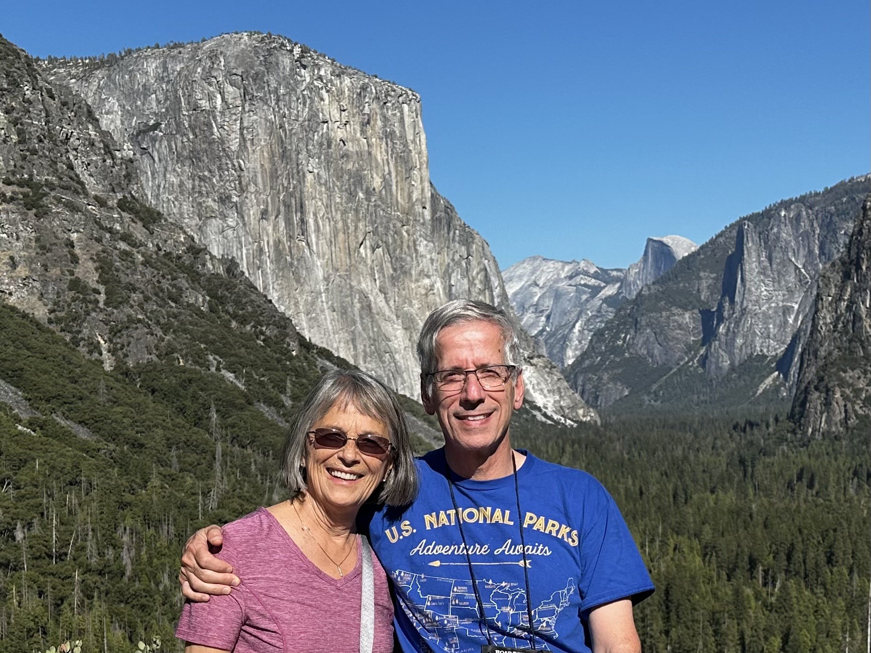 Photo of a middle-aged white couple posing at Yellowstone National Park.